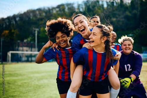 Foto Cheerful female players celebrate scoring goal on soccer match.
