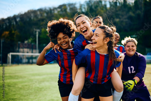 Cheerful female players celebrate scoring goal on soccer match. © Drazen