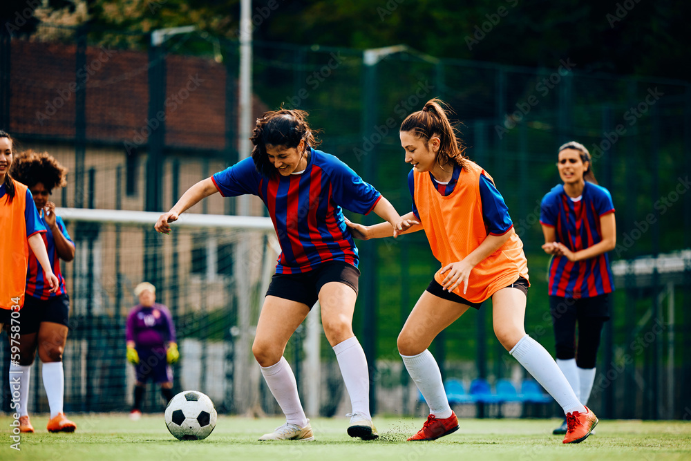 Obraz premium Female players in action during practice on soccer pitch.