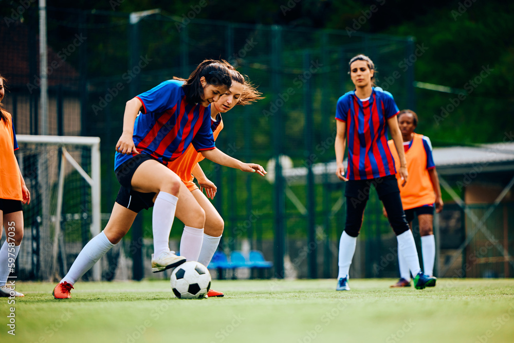 Naklejka premium Women's soccer team exercising on playing field.