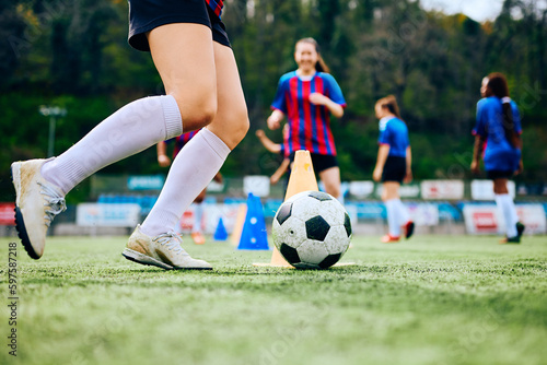 Close up of female player exercising with ball on soccer training at stadium.