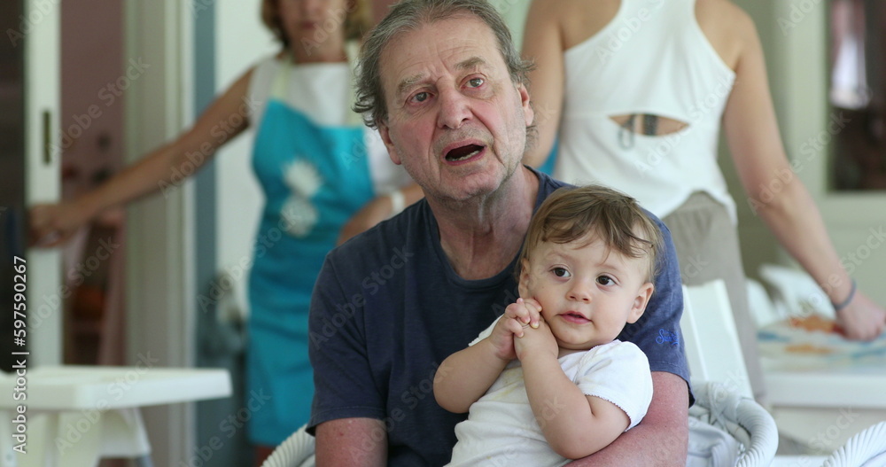 Obraz premium Baby clapping hands on grand-father lap