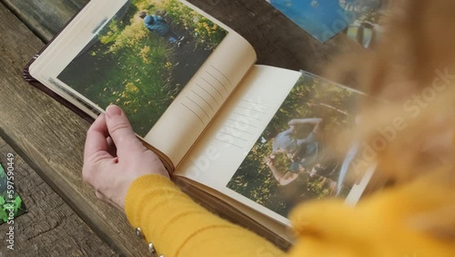 Person flipping through photo album filled with printed images of cherished memories. Photo printing concept. photo