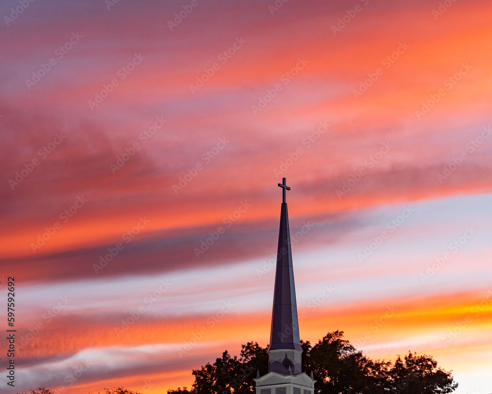 Pink clouds at sunset over a church steeple
