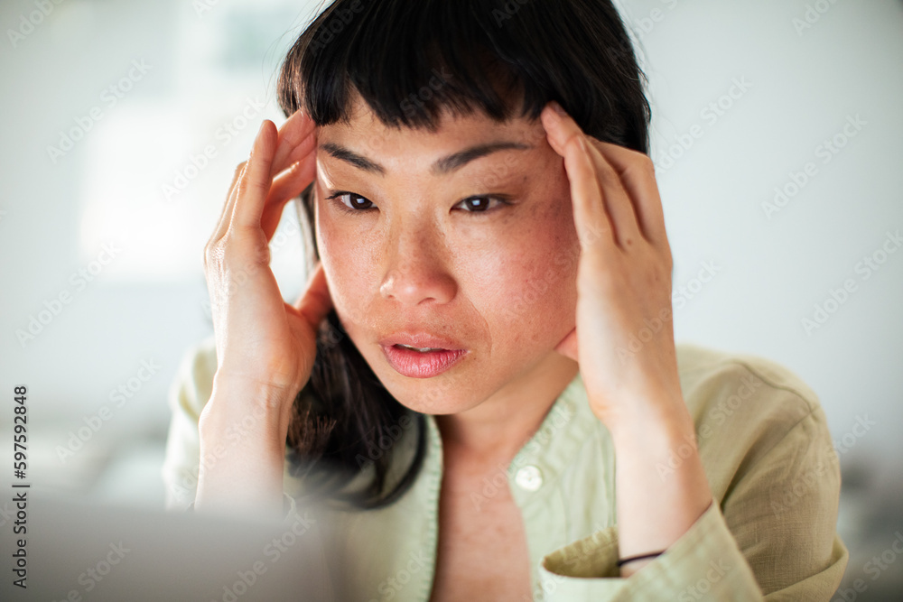 Young Japanese Woman working on a laptop in the kitchen Young Japanese Woman working on a laptop in the kitchen