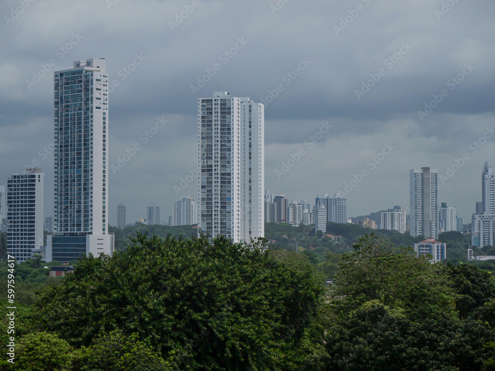 High-rise buildings of modern part of Panama City peek above lush green treetops