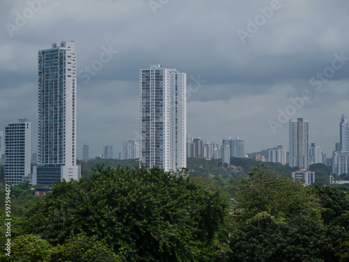 High-rise buildings of modern part of Panama City peek above lush green treetops © helivideo