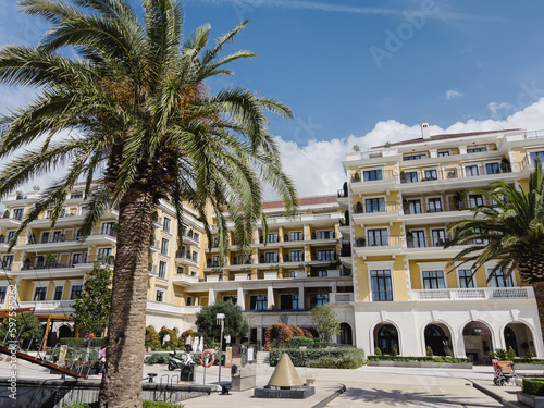 Green trees and bushes in front of the Regent Hotel. Porto, Montenegro