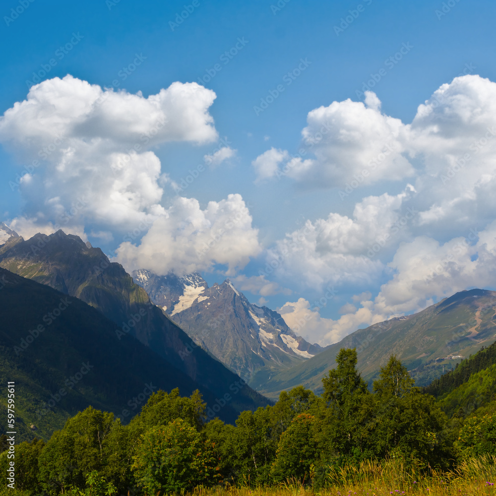 Fototapeta premium green mountain valley under blue cloudy sky