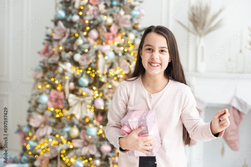 Photo of pretty funny schoolgirl opening gift box smiling indoors room home house Photo of pretty funny schoolgirl opening gift box smiling indoors room home house