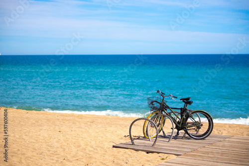 Fototapeta Naklejka Na Ścianę i Meble -  Male Cyclist in casual clothing, protective helmet and mirrored glasses riding on a bike near the sea during summer time