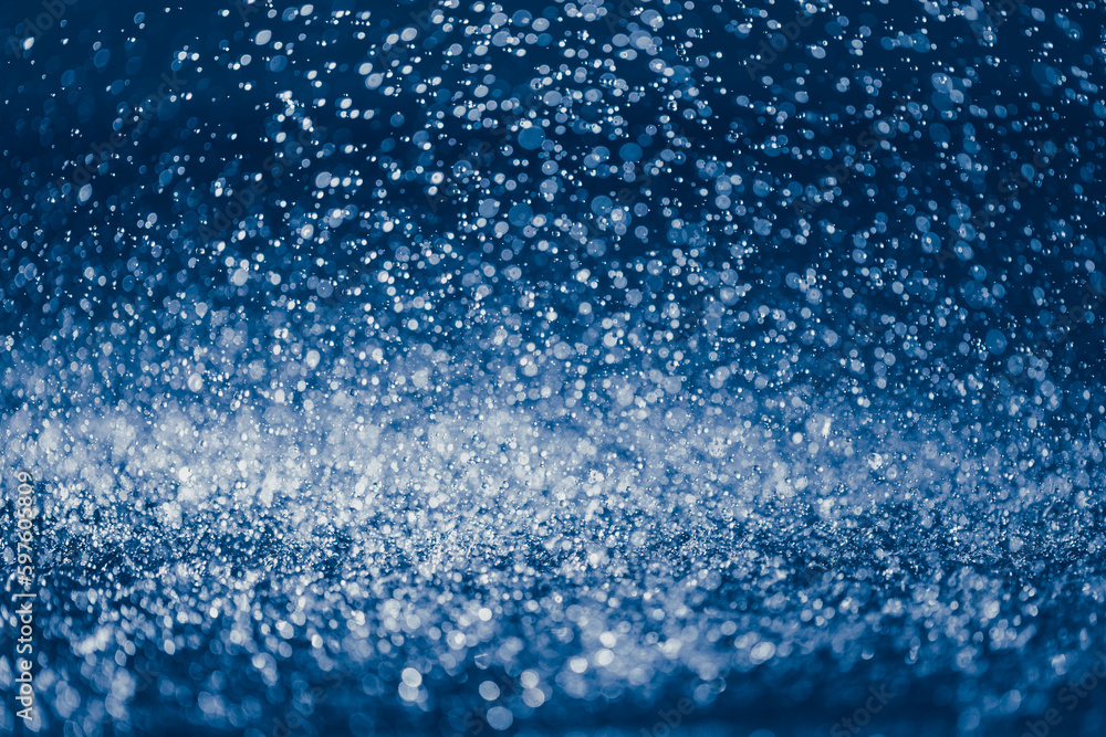Obraz premium rain water drops on the ground, blue bokeh background, close-up view
