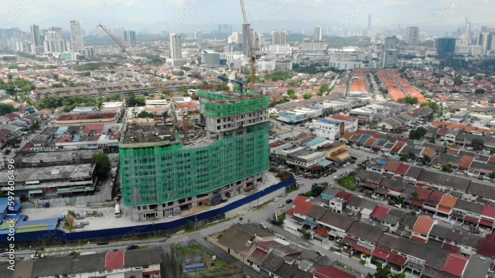Aerial view of a small houses surrounded by under construction building Aerial view of a small houses surrounded by under construction building