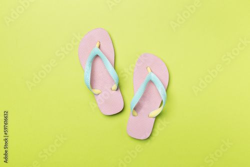 Bright flip flops on color background, top view