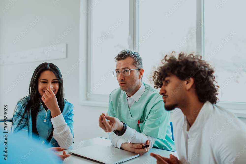 Obraz premium A group of multiethnic medical professionals including doctors, surgeons, and nurses are gathered in a hospital setting discussing patient care and using modern technology to address challenges in