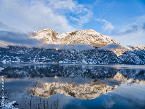 Snow capped mountains on Hardangerfjord in Eidfjord village, Norway