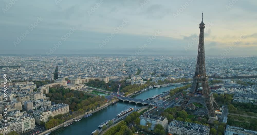Beautiful view of famous Eiffel Tower in France with magical morning cloud and fog. Wide establishing aerial drone fly over seine river in paris city center, best travel destination landmark in Europe Beautiful view of famous Eiffel Tower in France with magical morning cloud and fog. Wide establishing aerial drone fly over seine river in paris city center, best travel destination landmark in Europe