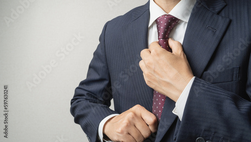 Fotografiet ネクタイを締めて身だしなみを整えるビジネスマン