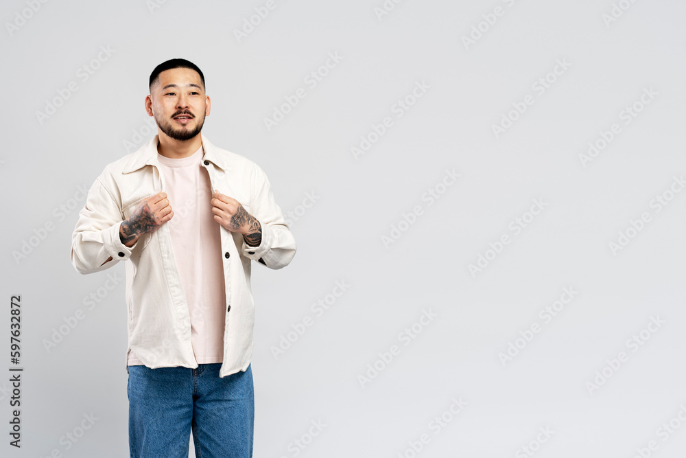 Portrait of attractive Asian man in stylish casual clothes standing isolated on gray background Portrait of attractive Asian man in stylish casual clothes standing isolated on gray background