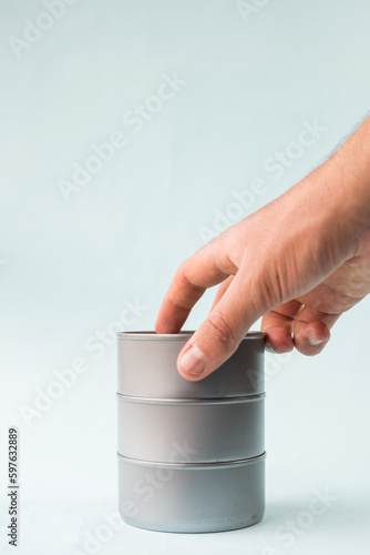 Hand taking food cans on blue background