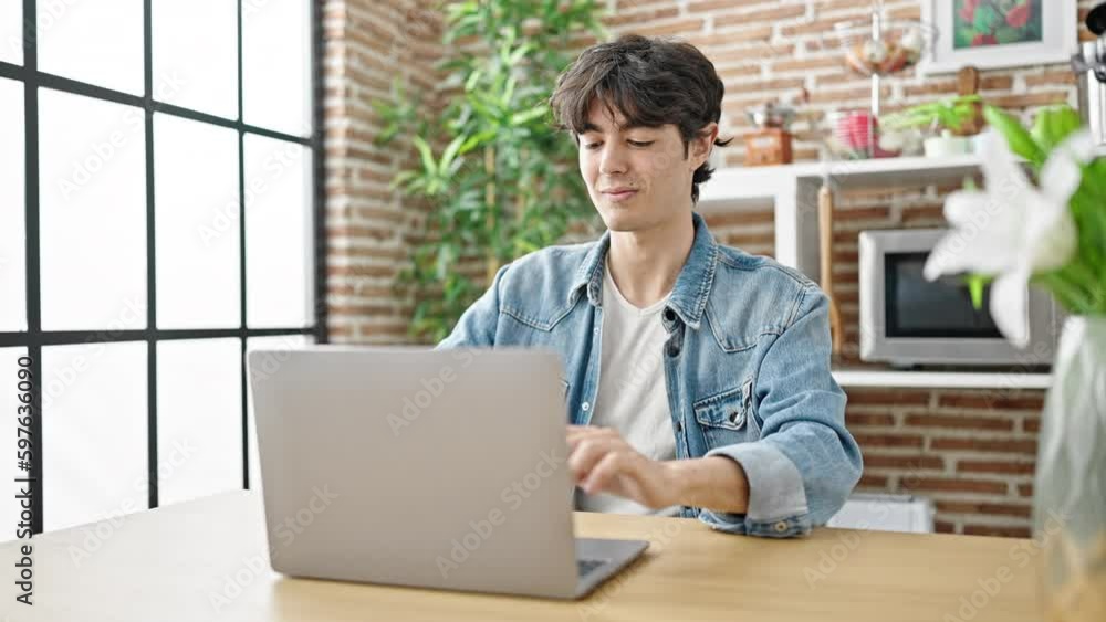 Young hispanic man using laptop sitting on table at dinning room Young hispanic man using laptop sitting on table at dinning room