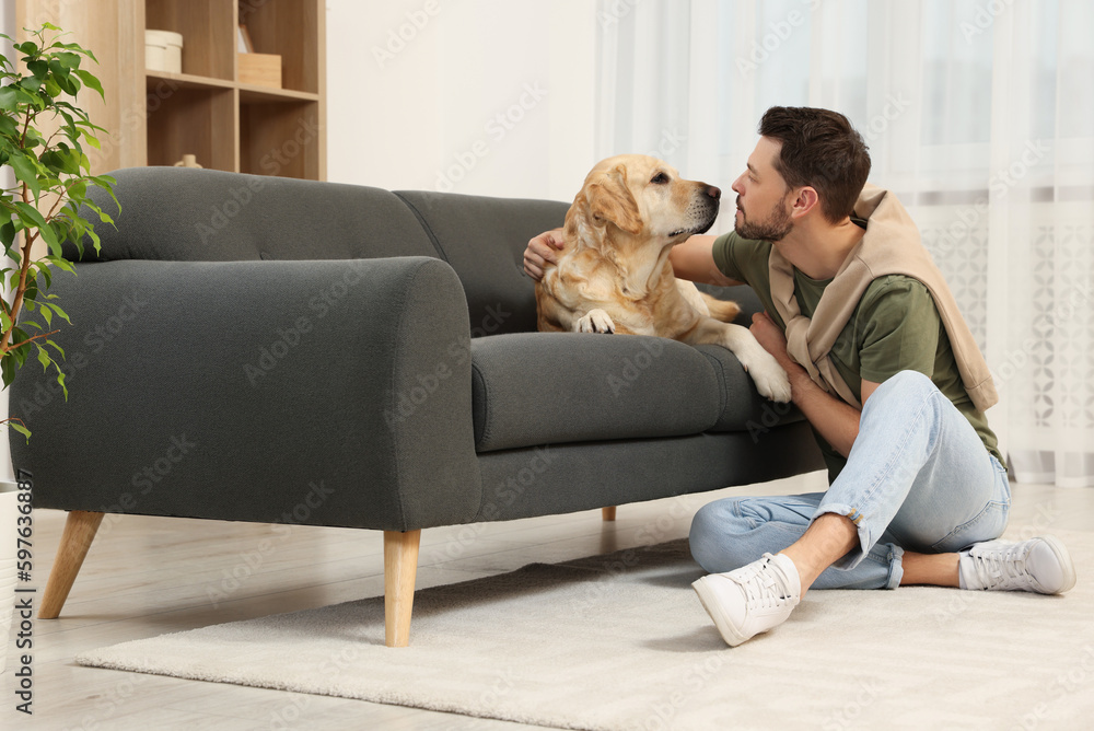 Happy man with his cute Labrador Retriever at home Happy man with his cute Labrador Retriever at home