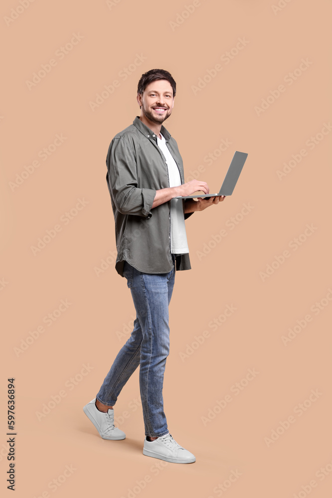 Happy man with laptop on beige background Happy man with laptop on beige background
