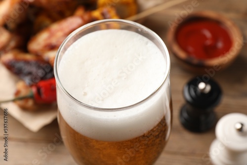 Glass of tasty beer on table, closeup view