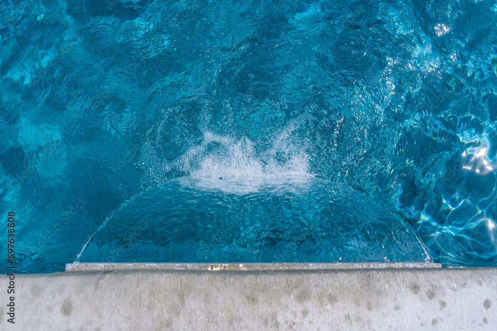 A serene photo capturing the perfect summer day with a vibrant swimming pool as the main focus, charmingly accompanied by a delightful duck enjoying a cool swim. A must-see for all nature and aquatic