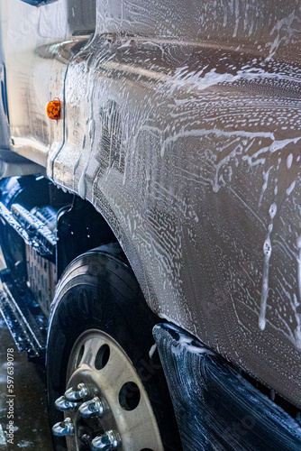 Obraz na płótnie A bustling truck maintenance shop, providing comprehensive truck wash services and expert repair solutions for both trucks and trailers. w salonie