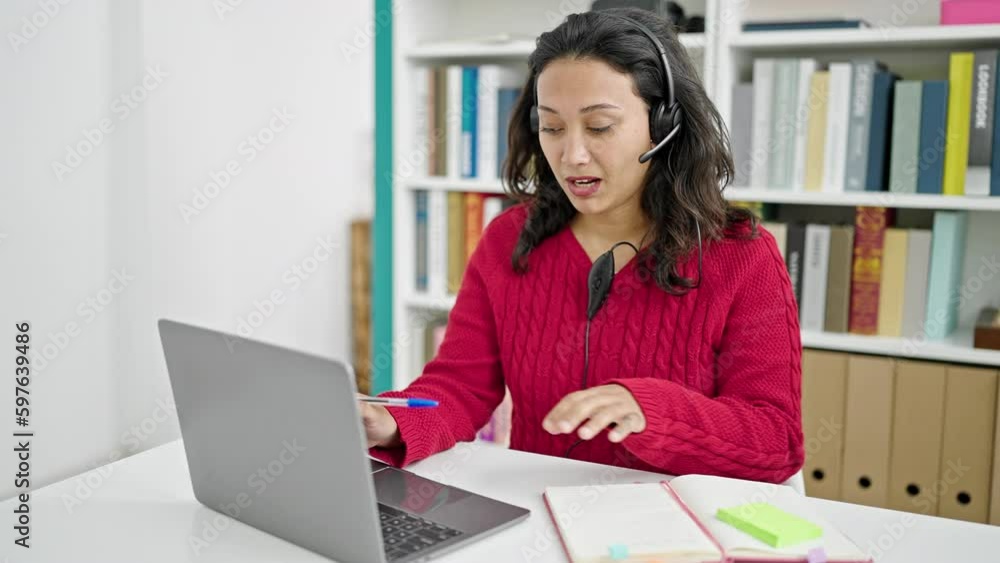 Young beautiful hispanic woman student having video call writing notes at library university Young beautiful hispanic woman student having video call writing notes at library university
