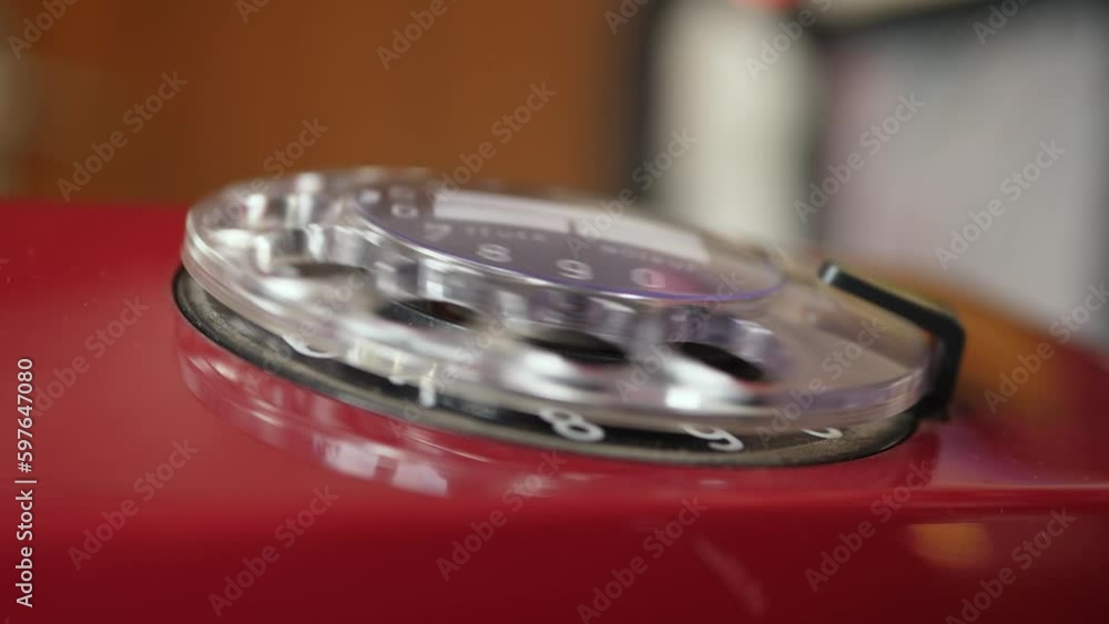A Child's Hand Picks Up the Receiver and Dials the Number 911 on a Real Red Rotary Phone A Child's Hand Picks Up the Receiver and Dials the Number 911 on a Real Red Rotary Phone