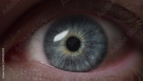 Blue eye opening widely. Macro close-up. Slow motion. 