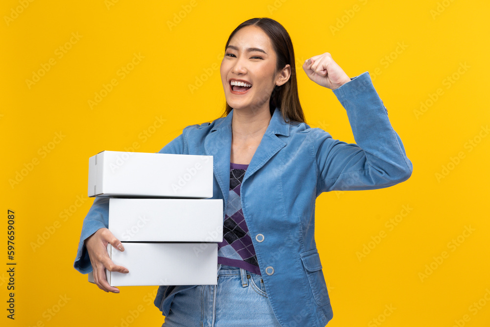 Happy Asian entrepreneur woman holding package parcel box isolated on yellow background., Delivery courier and shipping service concept. Happy Asian entrepreneur woman holding package parcel box isolated on yellow background., Delivery courier and shipping service concept.