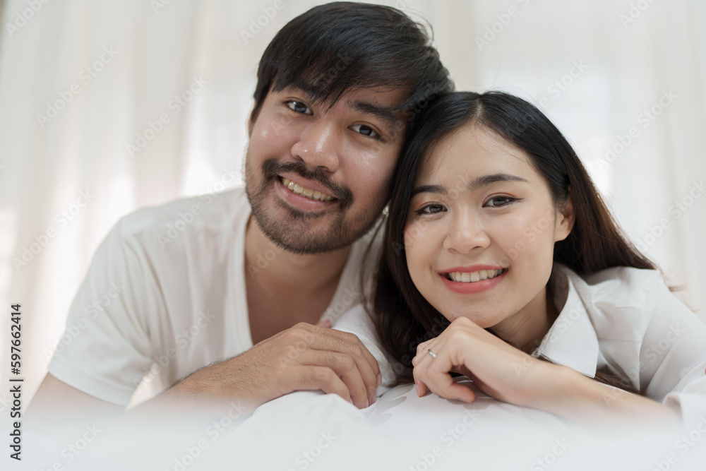 Asian Romantic couple in bed enjoying sensual foreplay Happy sensual young couple lying in bed together. Beautiful loving couple kissing in bed. Asian Romantic couple in bed enjoying sensual foreplay Happy sensual young couple lying in bed together. Beautiful loving couple kissing in bed.