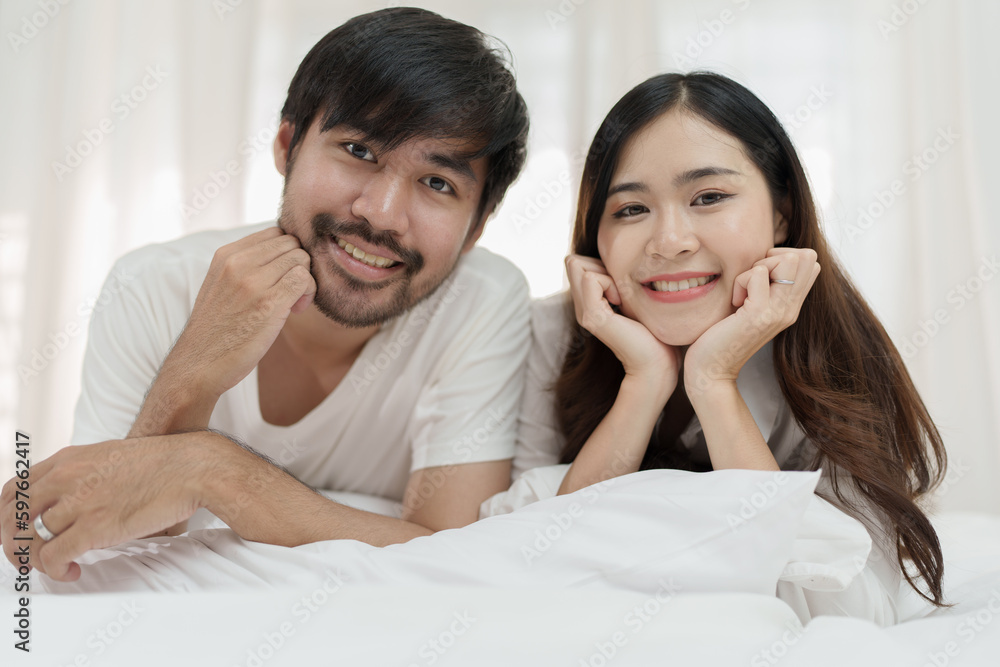Asian Romantic couple in bed enjoying sensual foreplay Happy sensual young couple lying in bed together. Beautiful loving couple kissing in bed. Asian Romantic couple in bed enjoying sensual foreplay Happy sensual young couple lying in bed together. Beautiful loving couple kissing in bed.