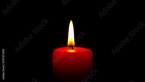 Single red candle flame lights, isolated on a black background