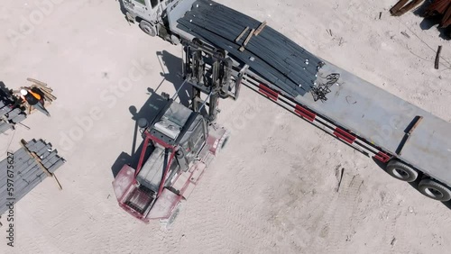 Aerial view overlooking a forklifts lifting steel sheets at a steelworks photo