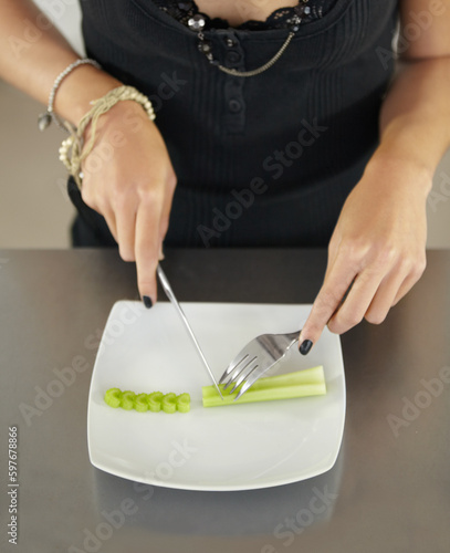 Closeup, vegetable and woman with anorexia, kitchen and eating disorder with utensils, wellness and nutrition. Zoom, female person or human with food, home or detox with diet, health issue or problem