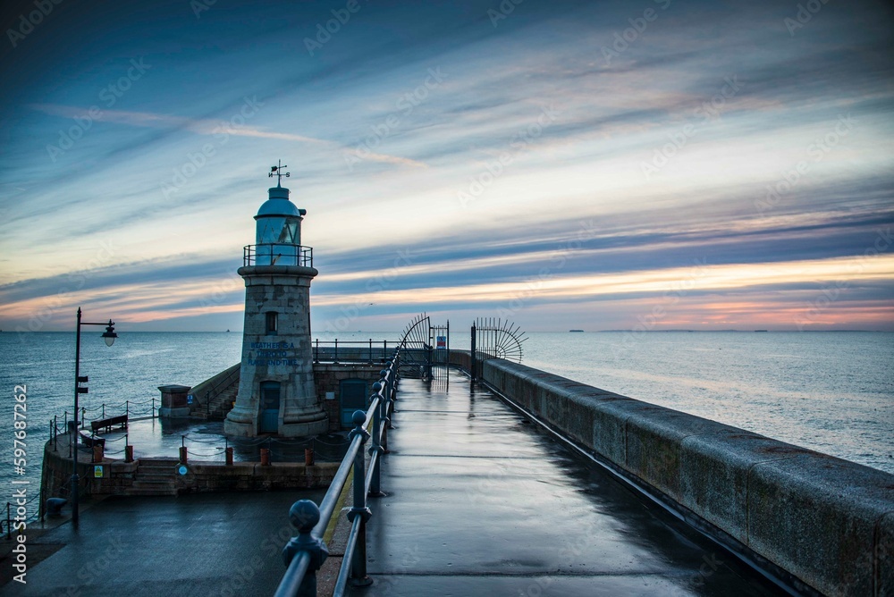 Folkestone's Harbour Arm and Lighthouse at dawn.