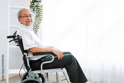 Photographie Portrait of an elderly man in a wheelchair alone with himself at home but contented with his lot in life