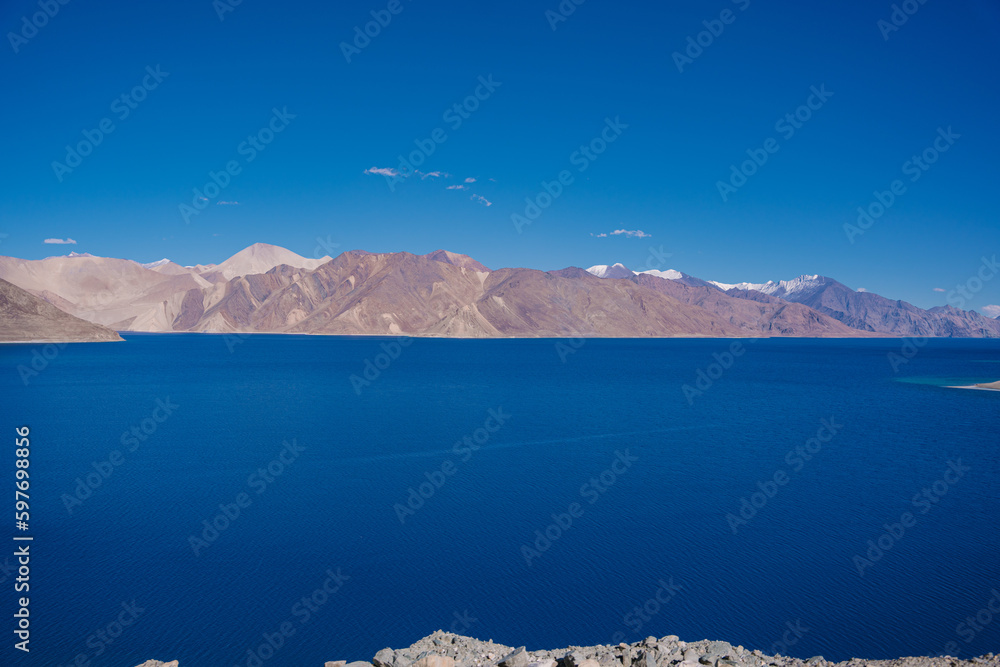 beautiful scenery of Pangong lake, blue lake water, blue sky, snow mountain surrounded at Pagong Tso, Leh, Ladakh, Jammu and Kashmir, India