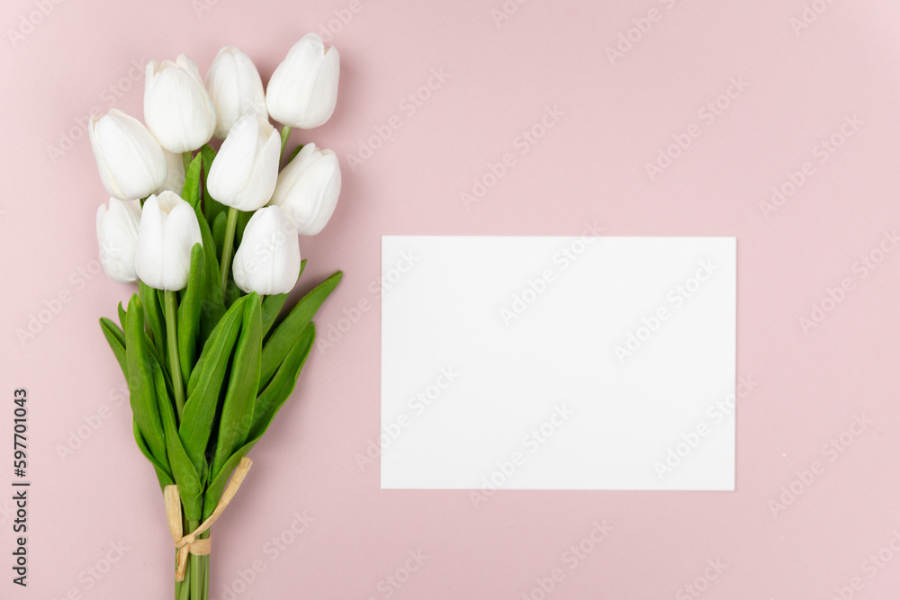Fototapeta premium bouquet of white tulips on a pastel pink background with a copy space for your text, spring flatlay composition for invitation, promotion, banners, card