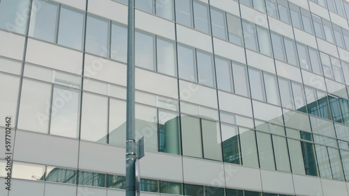 Office building windows and bottom view of skyscraper building with many corporate offices of successful companies. Real estate rental and commercial use.