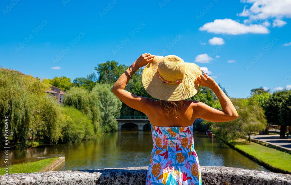 Woman with dress and hat visiting rural landscape in France,  Dordogne,  Perigueux