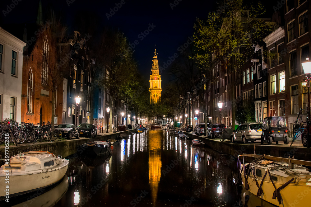 Night Shot of the Groenburgwal Canal with the Famous Tower of Zuiderkerk Beautifully Illuminated and Reflecting in the Water, Amsterdam