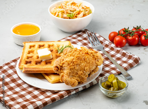 Deep-fried chicken and waffles poured with syrup.