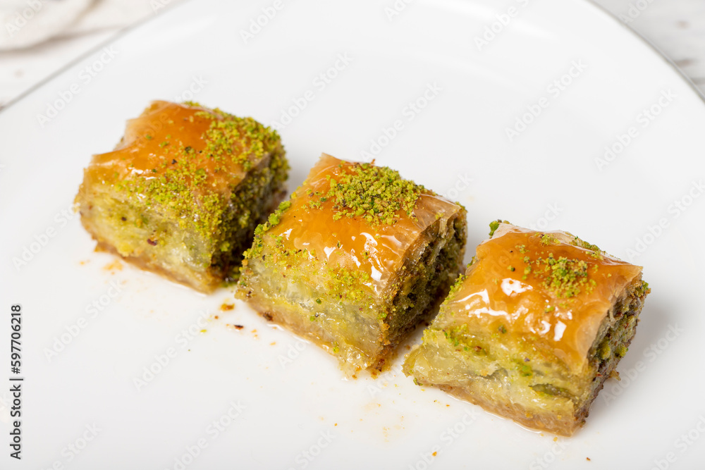 Baklava with pistachio on a wood background. Traditional Turkish baklava. Local name ankara sarmasi. Close up Baklava with pistachio on a wood background. Traditional Turkish baklava. Local name ankara sarmasi. Close up