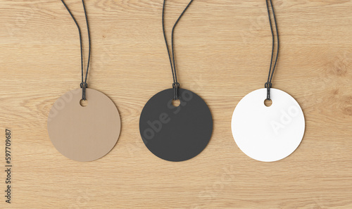 White, cardboard, black round tags mockup on wooden background. View directly above
