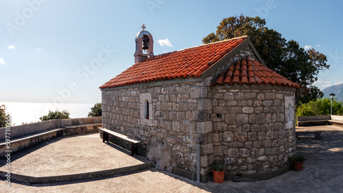 Saint Eliah church in Herceg Novi on stone flat plateau with sea horizon line at background photo